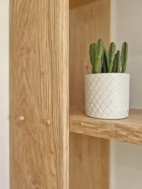 An oak upright fixed with timber dowels, carrying a live-edge oak shelf.
